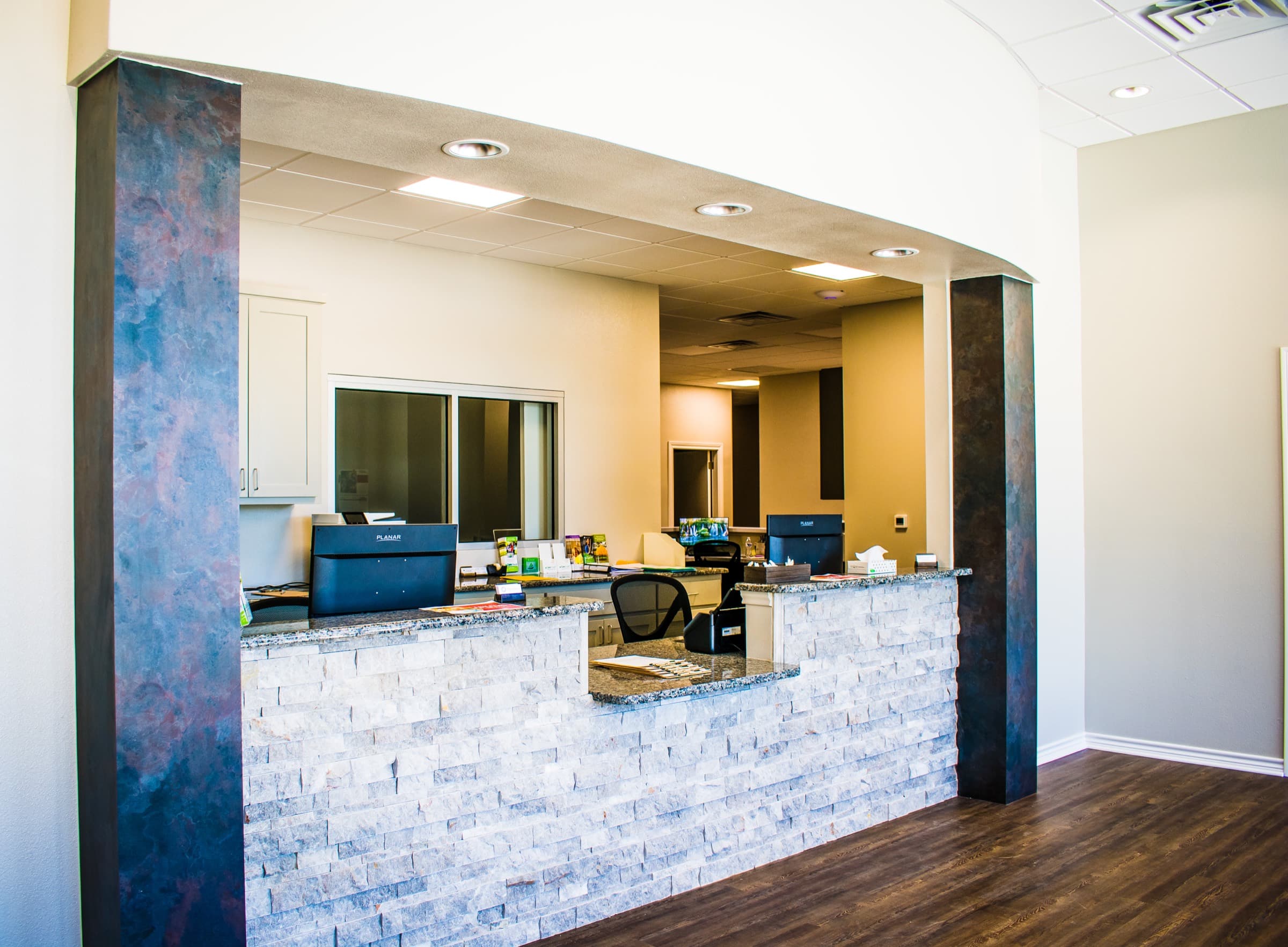 The Temple reception desk with a stone accent wall