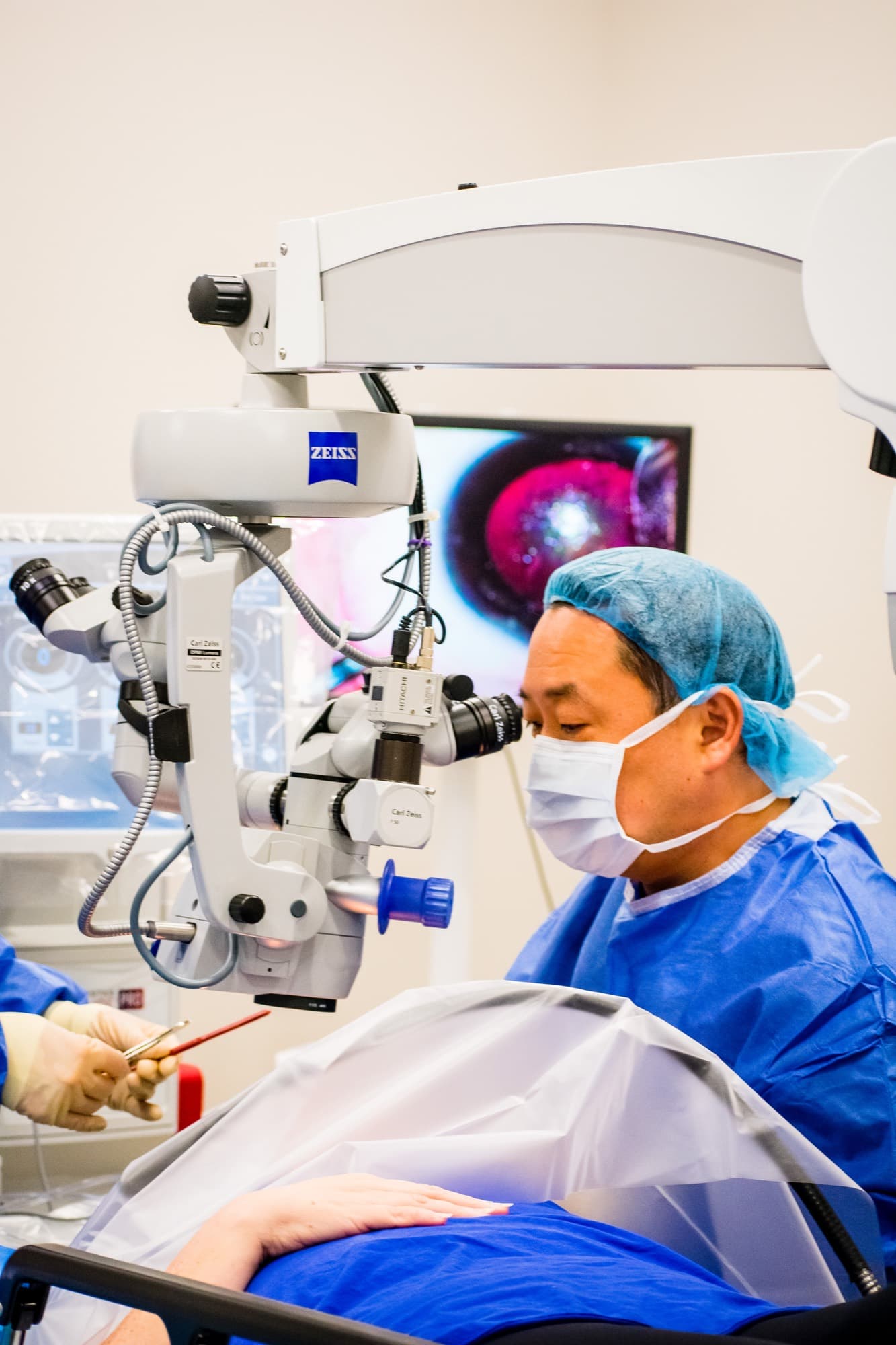 A Texas Vision surgeon at the operating microscope, the eye on the surgical monitor